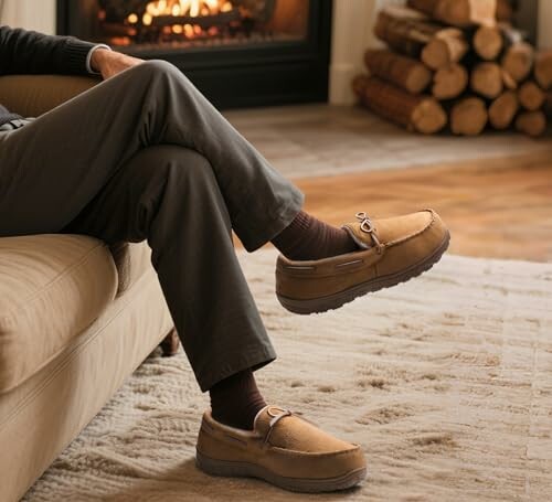 Person relaxing in slippers by a fireplace.